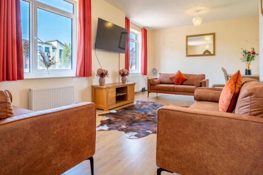 a living room with two couches and a tv at Posh Wetheringsett in Milton Keynes in Milton Keynes