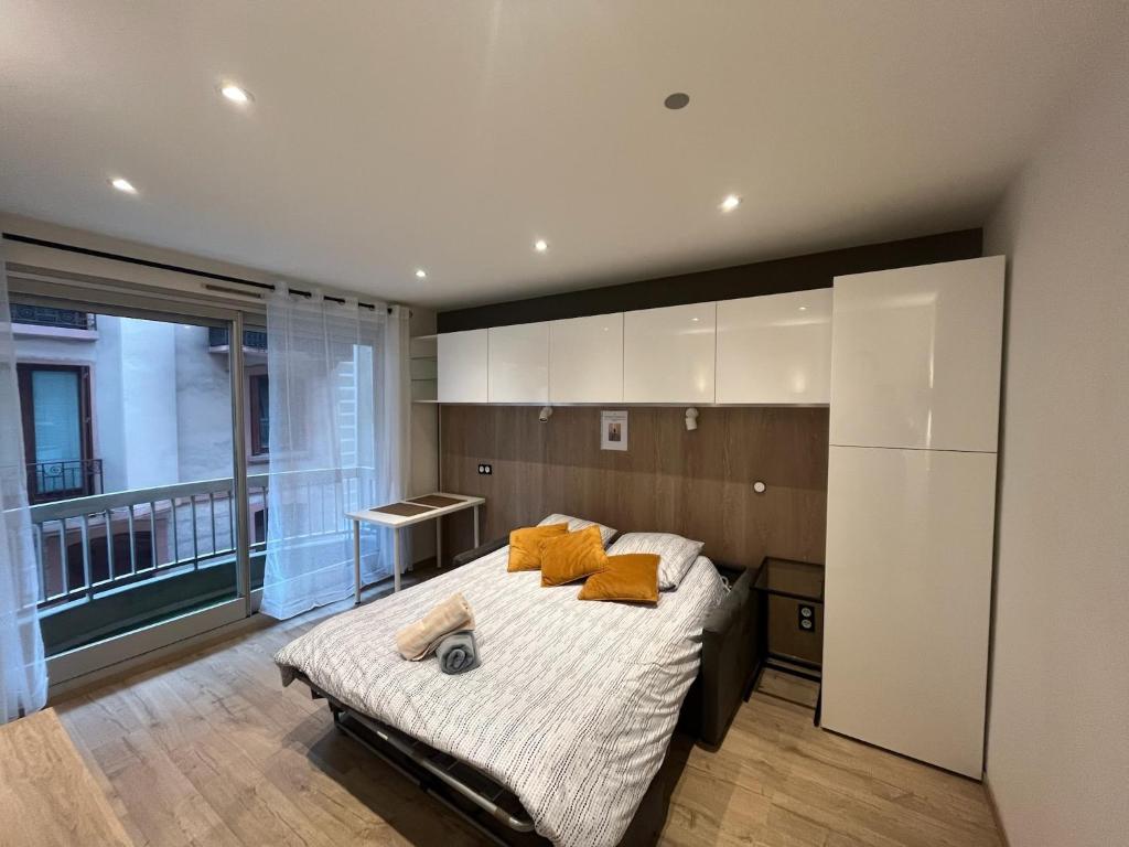 1 dormitorio con 1 cama con almohadas de color naranja en L'ecrin du temple, en Aix-les-Bains