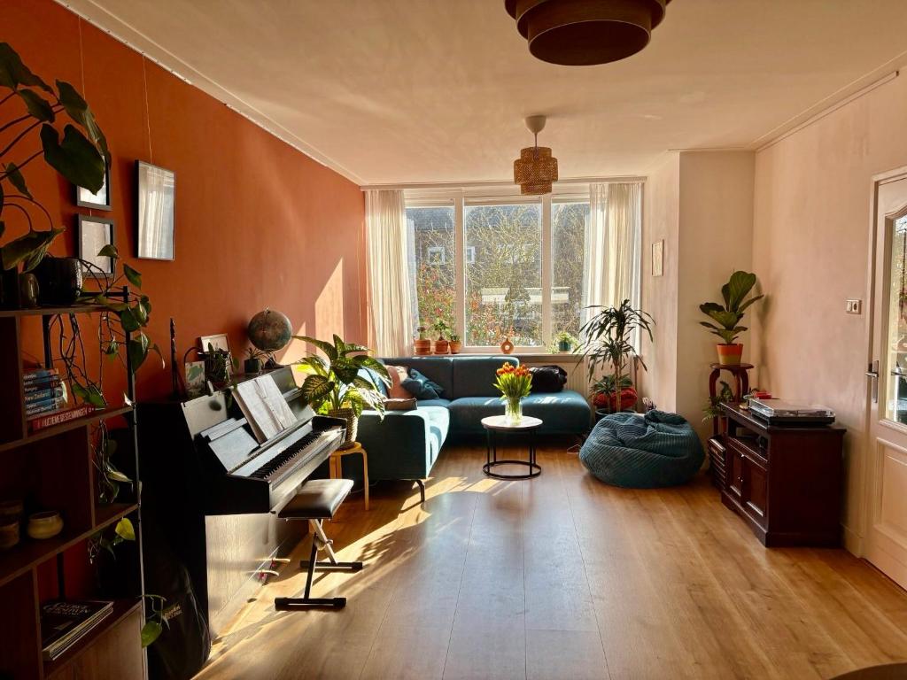 a living room with a couch and a piano at Family home in Haarlem with garden, near beach & Amsterdam in Haarlem