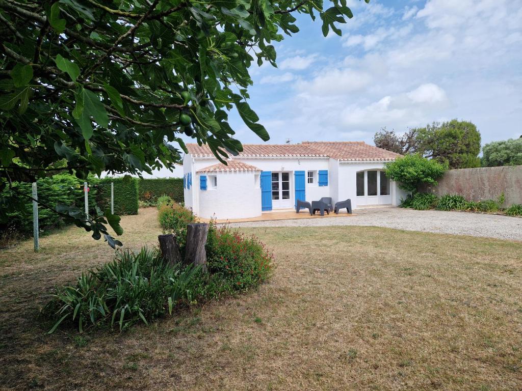 a white and blue house with a yard at Maison familiale à Barbâtre face à la dune, 3 chb, 2 SDB, 8 personnes in Barbâtre