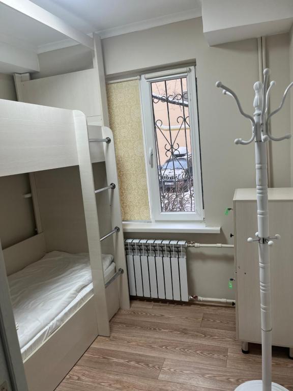 a small room with bunk beds and a window at Hostel Nomad in Almaty