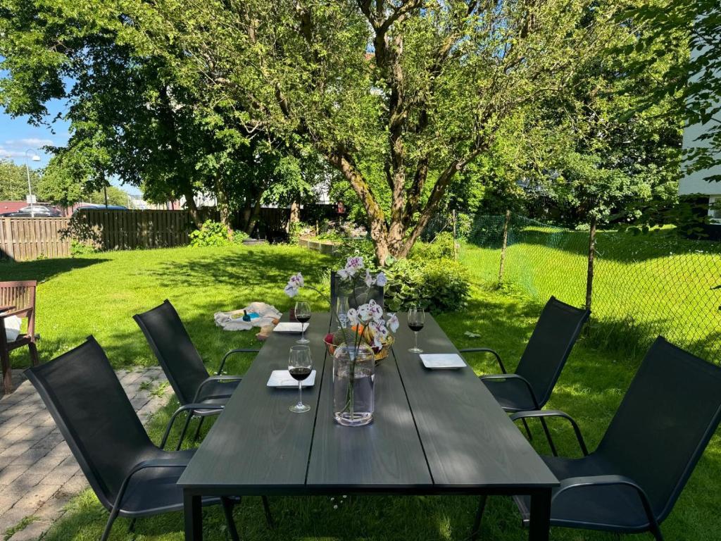 a long black table with chairs in a yard at HaHa Gothenburg City Apt for 2 in Gothenburg