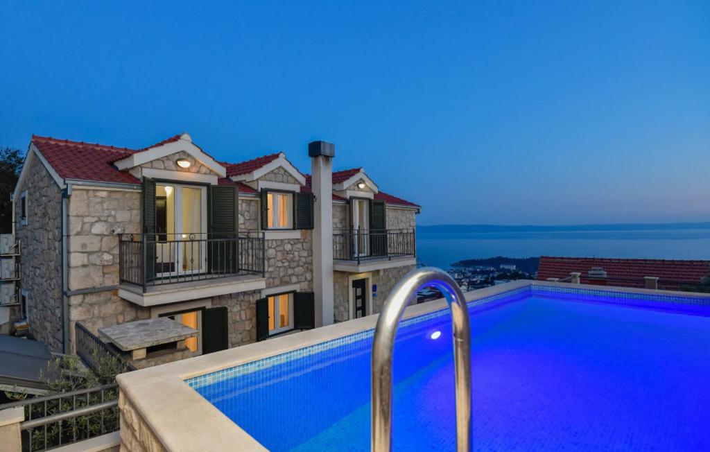 a villa with a swimming pool in front of a house at Villa Elizabeta Makarska by Villas Guide in Makar