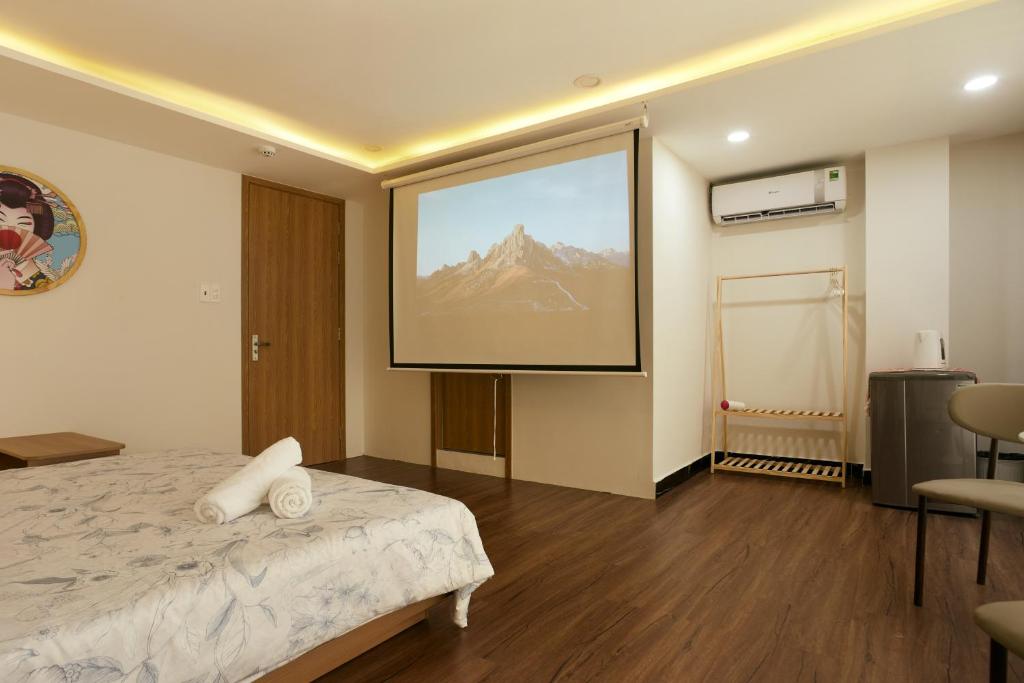 a large screen in a room with a bed at V Living Lam Sơn in Ho Chi Minh City