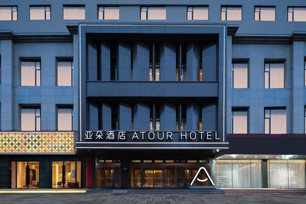 Atour Hotel Hohhot Hailiang Plaza Zhongshan Road Subway Station في هوهوت: اطلالة خارجية على عمارة سكنية مع فندق