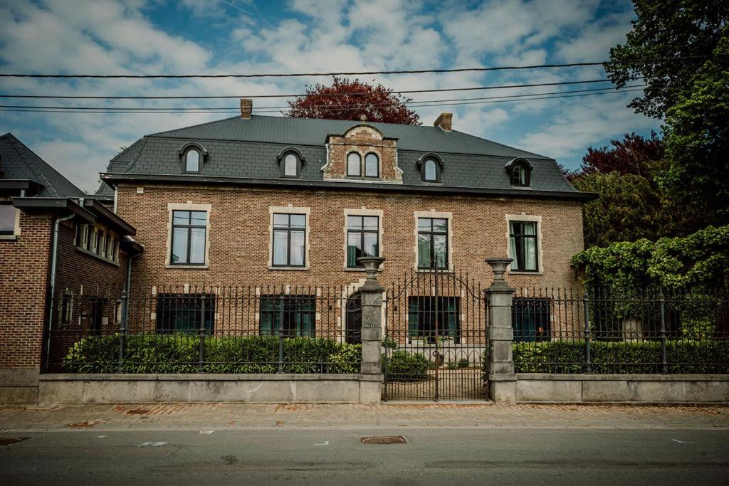 una gran casa de ladrillo con una valla delante de ella en Relais M B&B, en Frasnes-lez-Anvaing