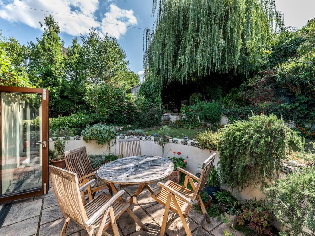 a patio with a table and chairs in a garden at Pass the Keys Charming 3-Bed Bungalow with Character Garden in London