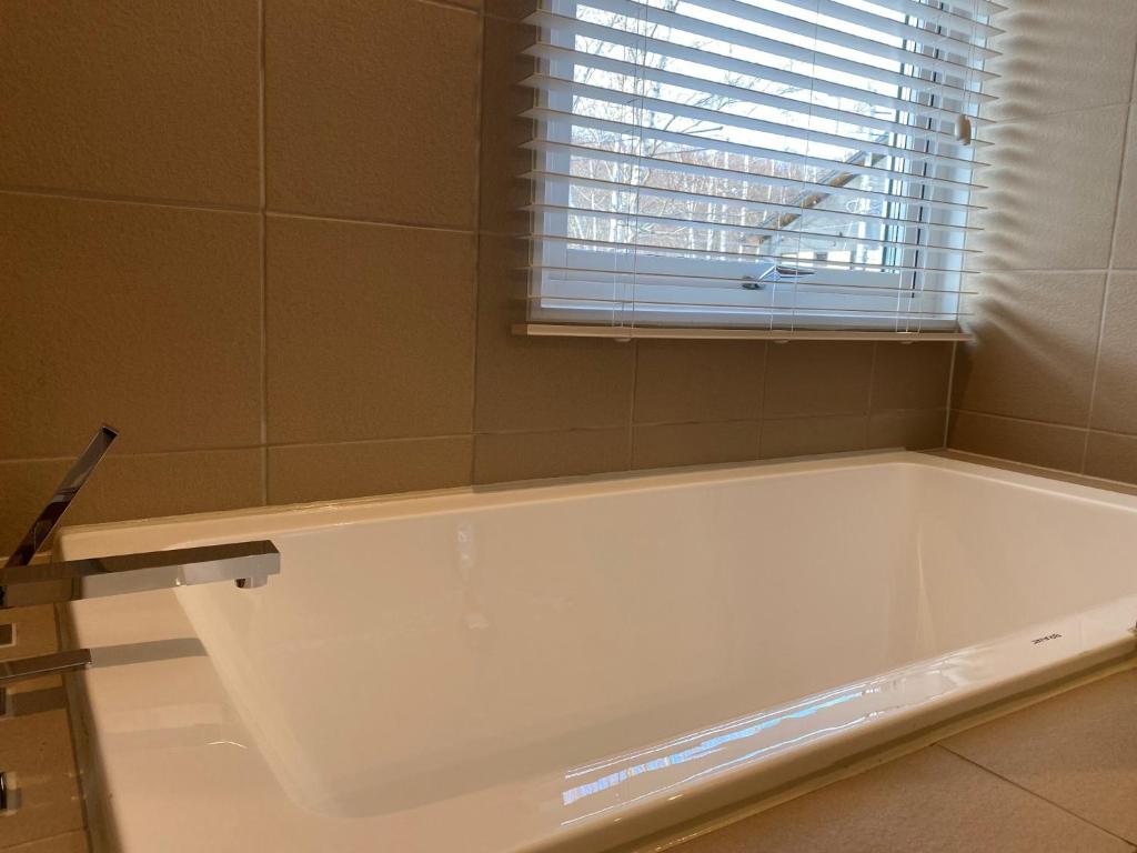 a white bath tub in a bathroom with a window at KAMMA - Vacation STAY 12882v in Kutchan