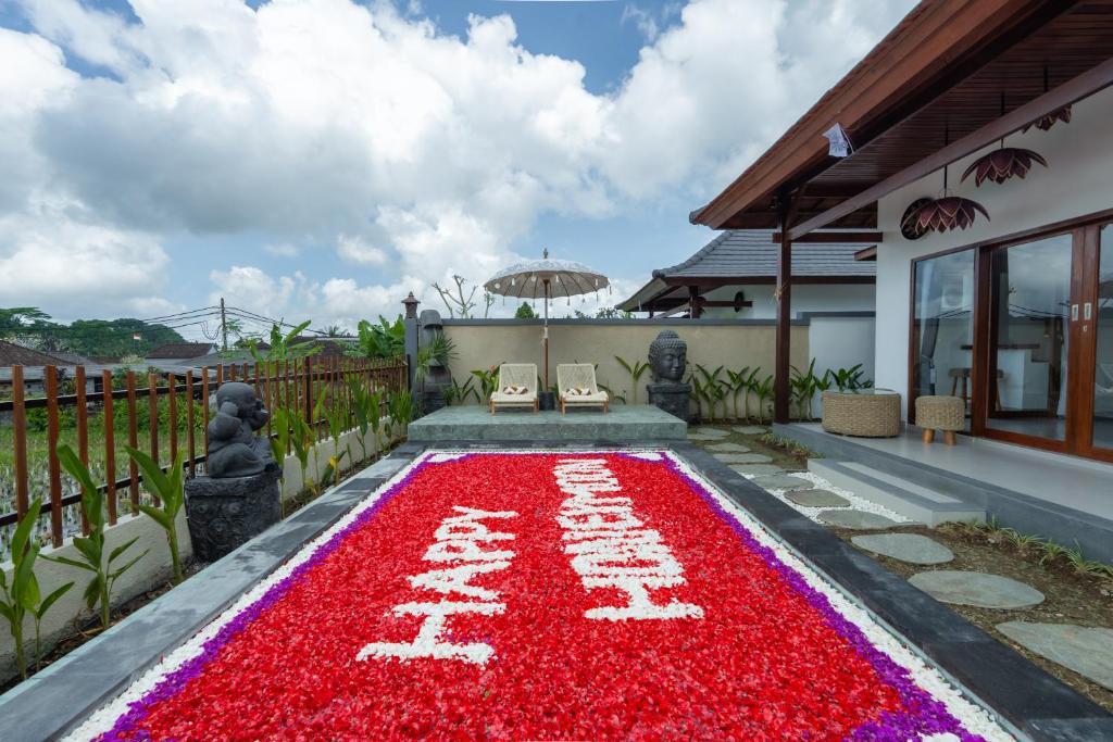 a carpet of red flowers in front of a house at Mahayani Ubud Villa in Tegalalang