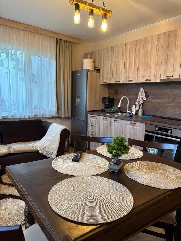 a kitchen with a wooden table with four chairs and a kitchen with a tableablish at Apartment Hristina in Dobrinishte