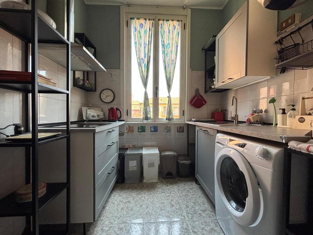 eine Küche mit Waschmaschine und Fenster in der Unterkunft Milano da Me - Ampio appartamento con 2 camere da letto in Mailand