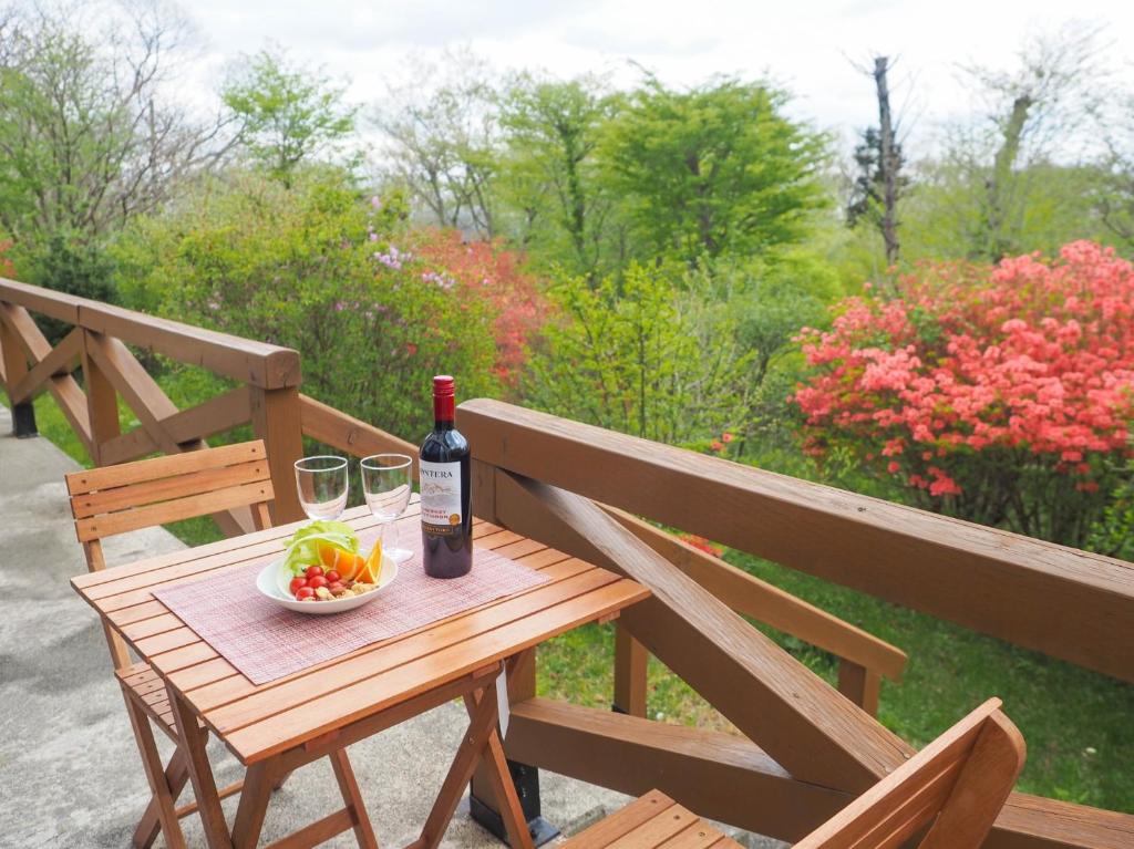 a wooden table with a bottle of wine and a bowl of fruit at Rigeru - Vacation STAY 11338 in Nasu