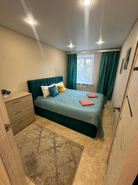 a small bedroom with a bed and a window at Абдирова 19 в центре in Karagandy