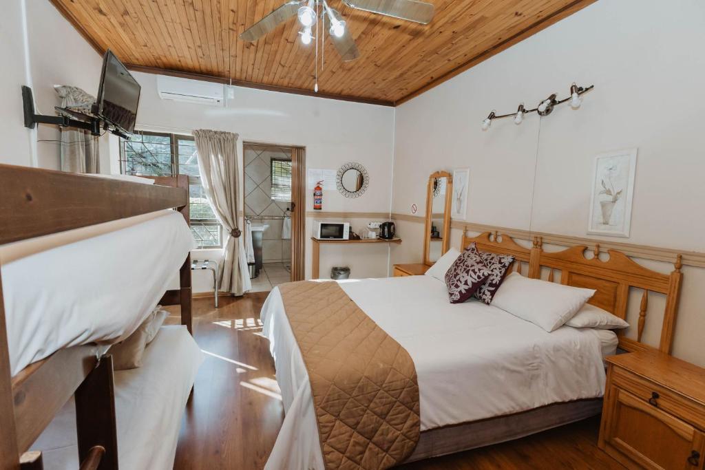 a bedroom with a bed and a ceiling fan at CASTLE WITH A VIEW in Bloemfontein