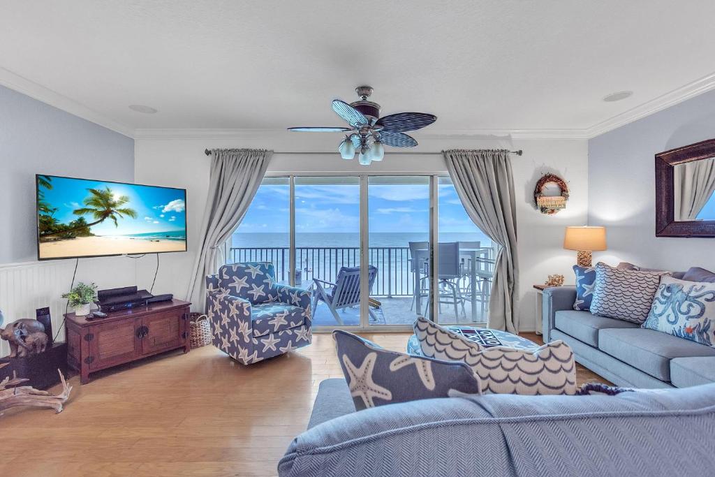 un soggiorno con un divano e un ventilatore a soffitto di Oceanside 302 a Clearwater Beach