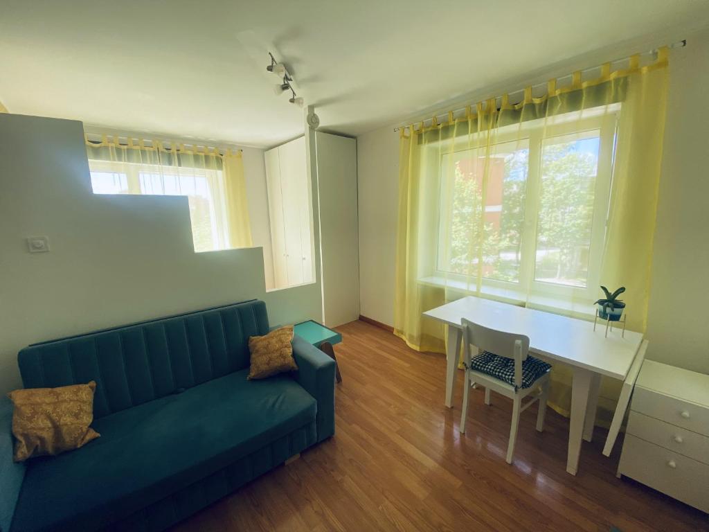 a living room with a blue couch and a table at Cosy Studio in Tartu Center in Tartu