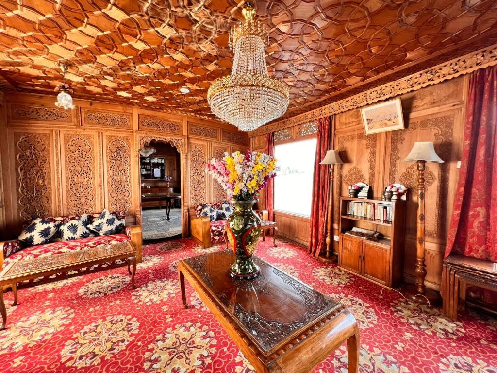a living room with a vase of flowers on a table at Dal lake group of houseboats in Srinagar