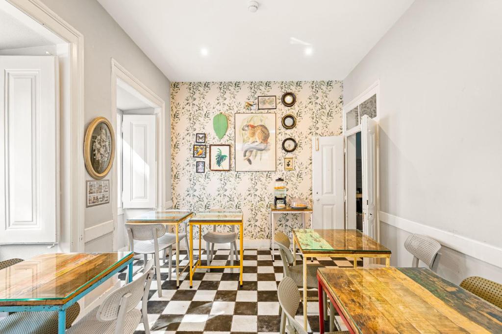 a dining room with tables and chairs and a checkered floor at Casa do Jasmim by Shiadu in Lisbon