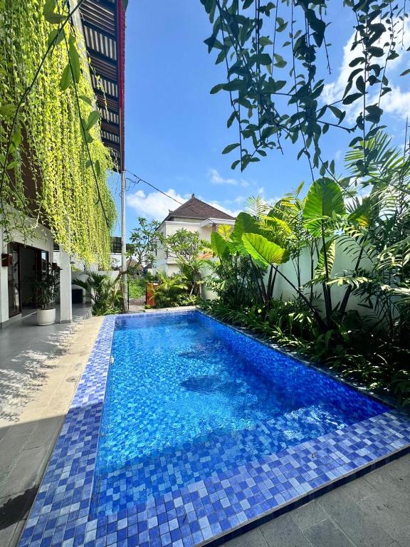 a blue tile swimming pool in front of a building at Casa Serena Cemagi in Canggu