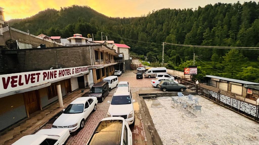 a bunch of cars parked in a parking lot at Velvet Pine Hotel in Abbottābād