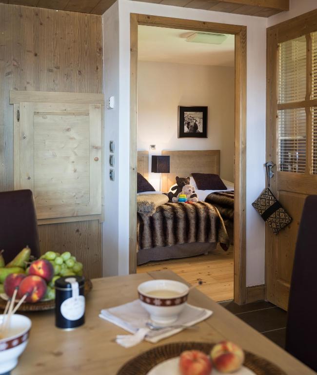 a bedroom with a bed and a table with a bowl of fruit at CGH Résidences &amp; Spas Chalet Les Marmottons in La Rosière