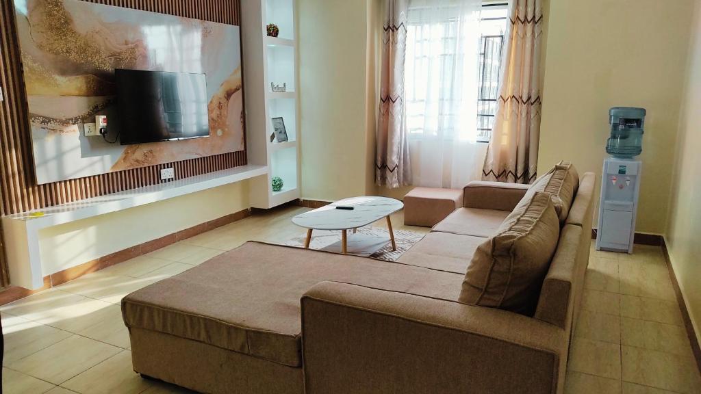 a living room with a couch and a table at Mayree Homes in Langata Rongai