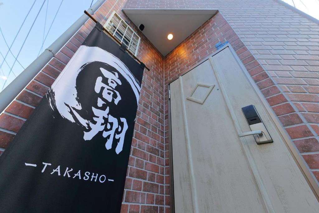 大阪市にあるTakasho TAKASHO -HANAZONO MINAMI- - Vacation STAY 69476vの煉瓦造りの建物の脇の看板