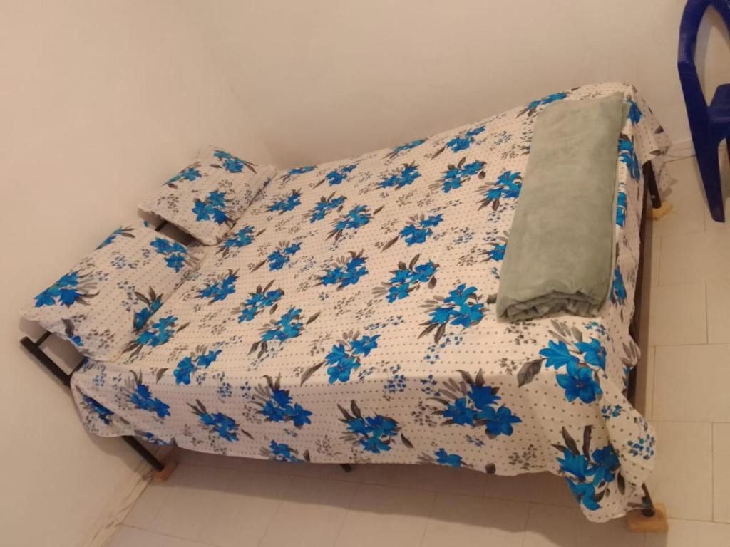 a bed in a room with blue flowers on it at Accueil 1 in Rufisque