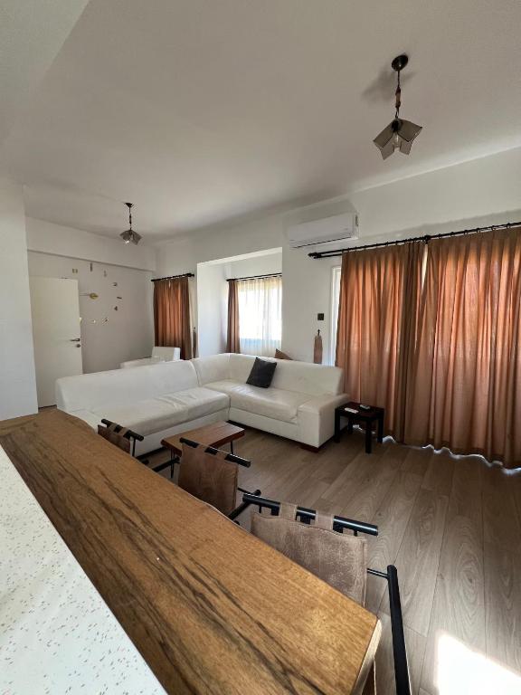 a living room with a white couch and a table at 3artı1 iki katlı daire in Aglantzia