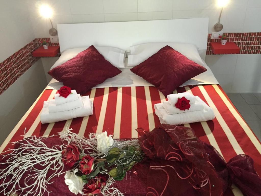 a bedroom with a bed with shoes and flowers on it at Rosa di Ortigia in Syracuse