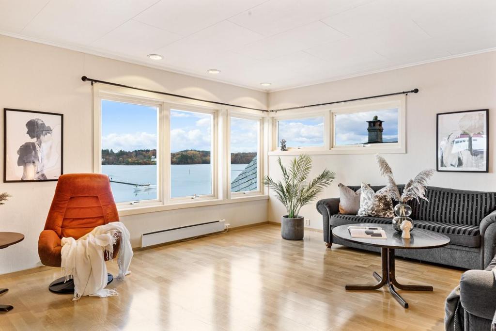 un soggiorno con un divano e una poltrona di Fjordside Escape - Spacious apartment with amazing views a Tysnes