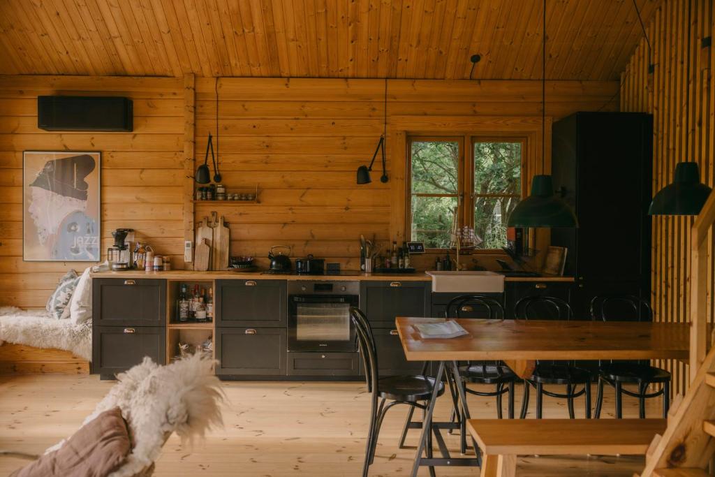 a kitchen and dining room in a log cabin at Family-Friendly Log Cabin Near Tisvildeleje Beach in Vejby