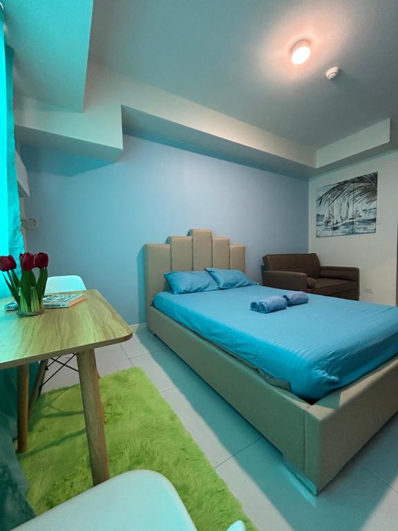 - une chambre bleue avec un lit et une table dans l'établissement Horizons101 - Studio Type Room, à Cebu