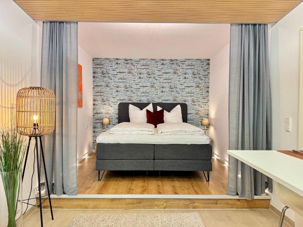 een slaapkamer met een bed met een bakstenen muur bij Kaiser Wilhelm - Altstadt Design Apartment in Freiburg im Breisgau