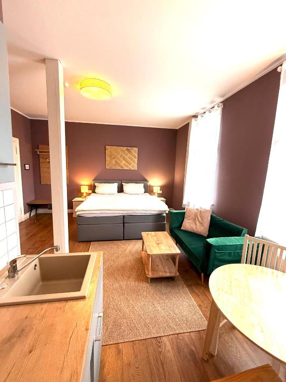 a bedroom with a bed and a couch and a table at Pension im historischem Bahnhof in Fehrbellin kein Frühstück in Fehrbellin