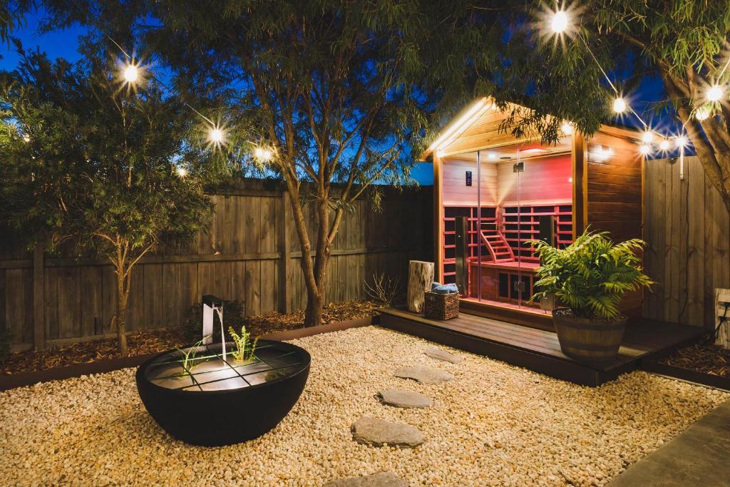 a backyard with a fire pit and a house with lights at La Casa Serenità - peaceful retreat with infrared sauna in Moolap