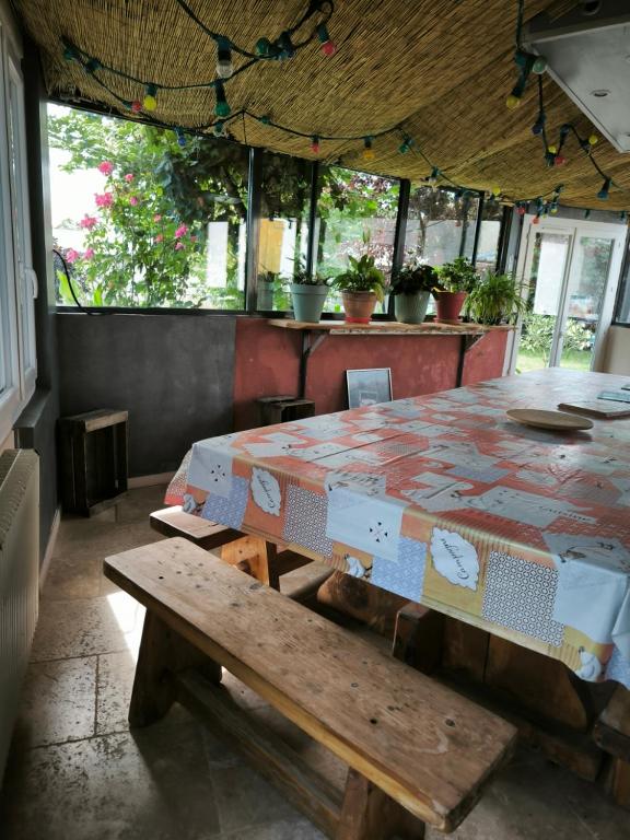 Una mesa con cajas encima y un banco. en chez jacques et cricri, en Monthodon