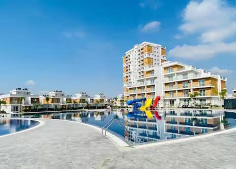 a large apartment building next to a body of water at Royal Sun Elite Daire in Aglantzia