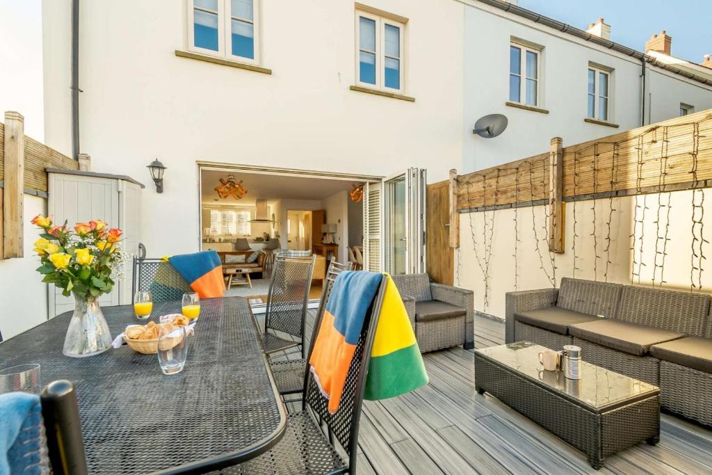 a patio with a table and chairs on a deck at Cartref - Saundersfoot in Saundersfoot