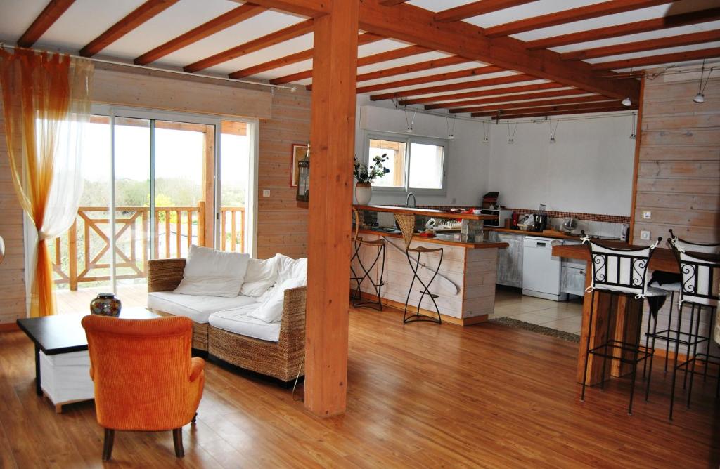 a living room with a couch and a kitchen at Chambre sur jardin, proche plage in Bidart