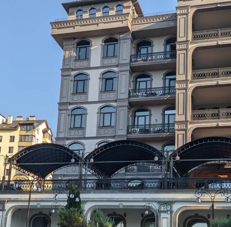 a tall building with balconies on the side of it at Апартаменти біля парку з бюветом мінеральної води in Truskavets