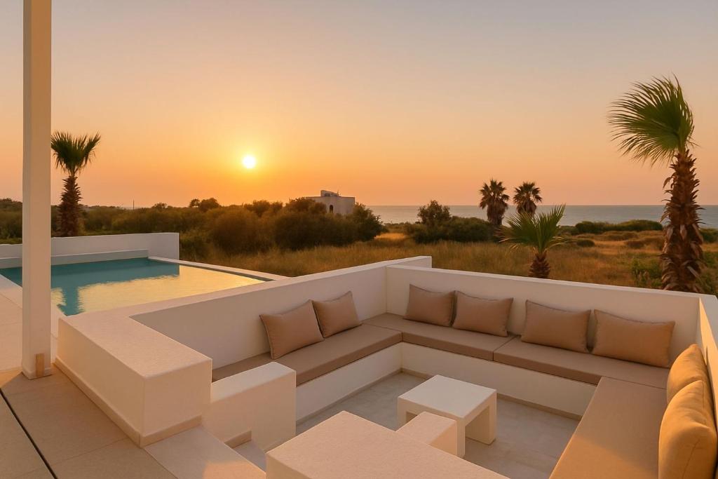 - un salon avec un canapé et un coucher de soleil dans l'établissement Seadream Villa, à Lakhania