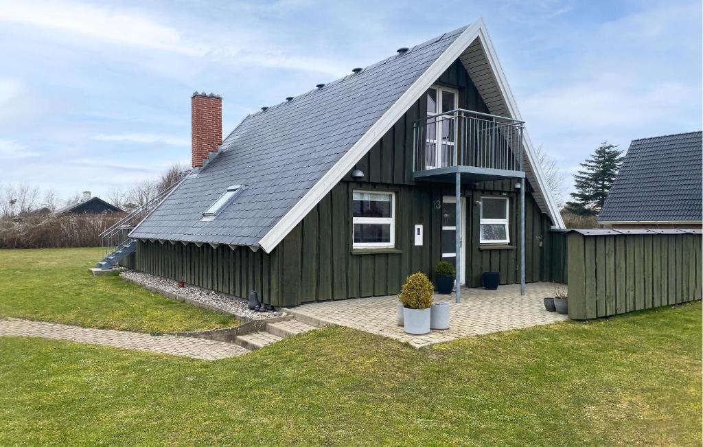 una casa verde con techo de gambrel en Awesome Home In Samsø With Wifi, en Sælvig