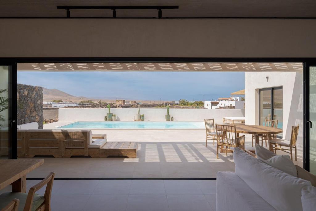 un patio con piscina, mesa y sillas en Villa Victoria El Roque, en Roque