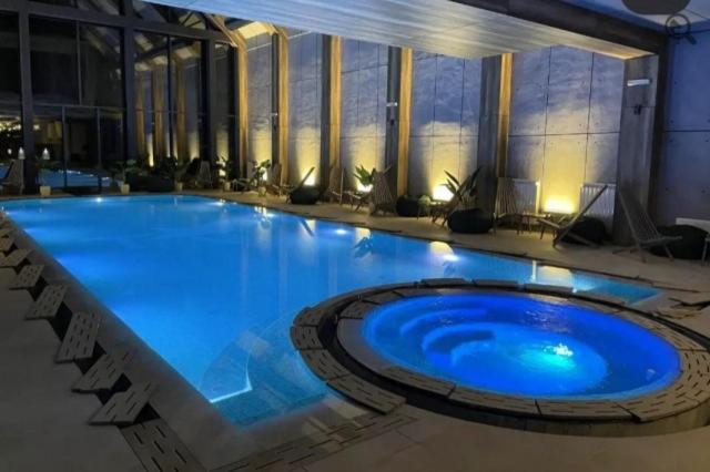 a large blue swimming pool in a building at Titova Vila - Golden Peak Residence in Zlatibor