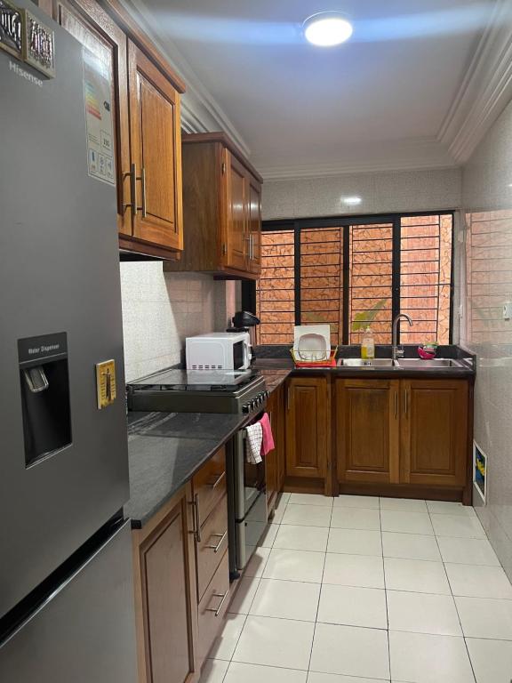 a kitchen with wooden cabinets and a stove top oven at OSIF Chic City Retreat in Yaoundé