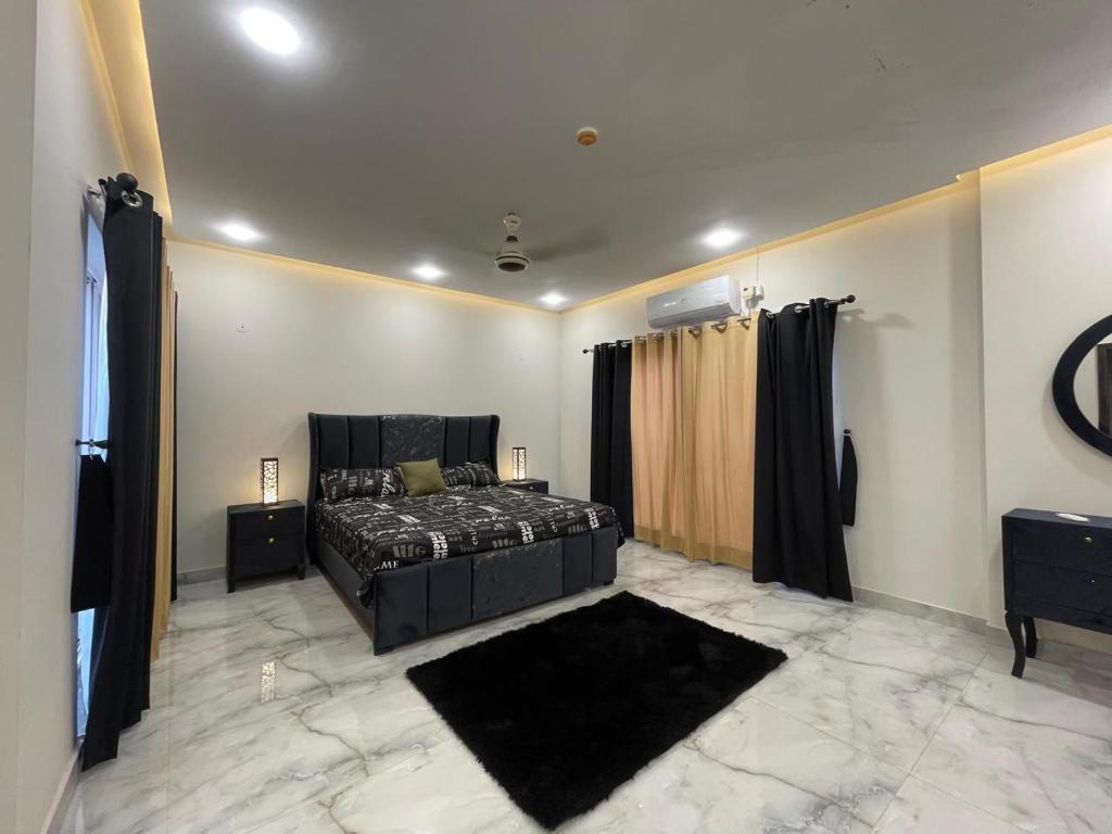 a bedroom with a black bed and a black rug at Comfort Home in DHA Phase 9 Lahore in Lahore