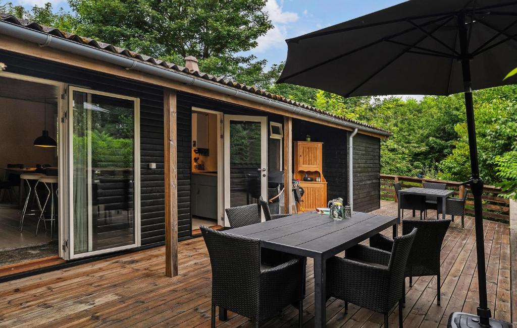 a patio with a table and chairs and an umbrella at 3 Bedroom Awesome Home In Aabenraa in Aabenraa