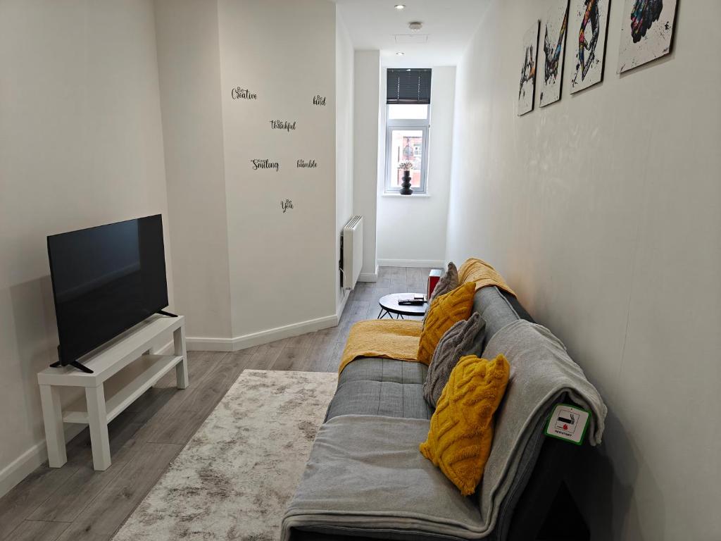 a living room with a couch and a flat screen tv at Newly Furnished Modern 1 bedroom City Apartment in Leicester