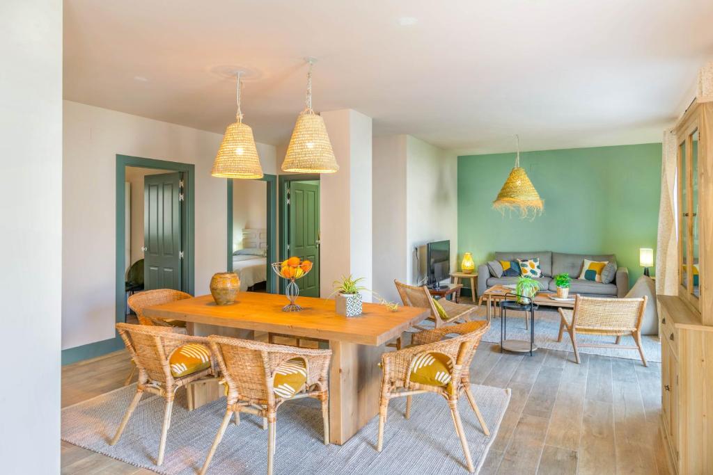 a living room with a wooden table and chairs at Espaciosa casa a 15 min de Sendaviva y Bardenas in Cadreita